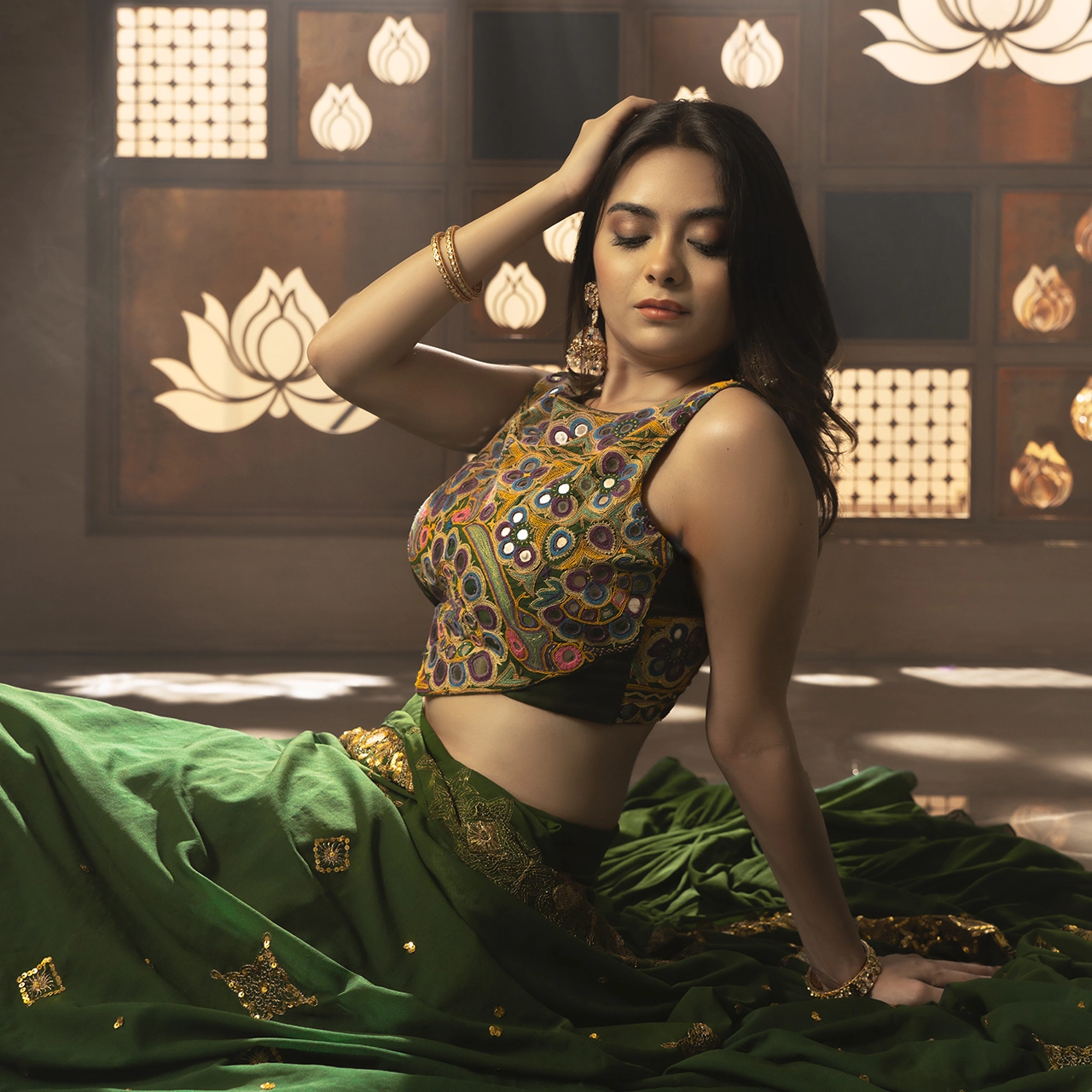 Photography Portfolio Cultural fusion fashion portrait with green silk saree and Kutch mirror-work embroidery blouse against lotus motif wall - Content Crest Media contemporary Indian fashion photography portfolio Ahmedabad Gujarat
