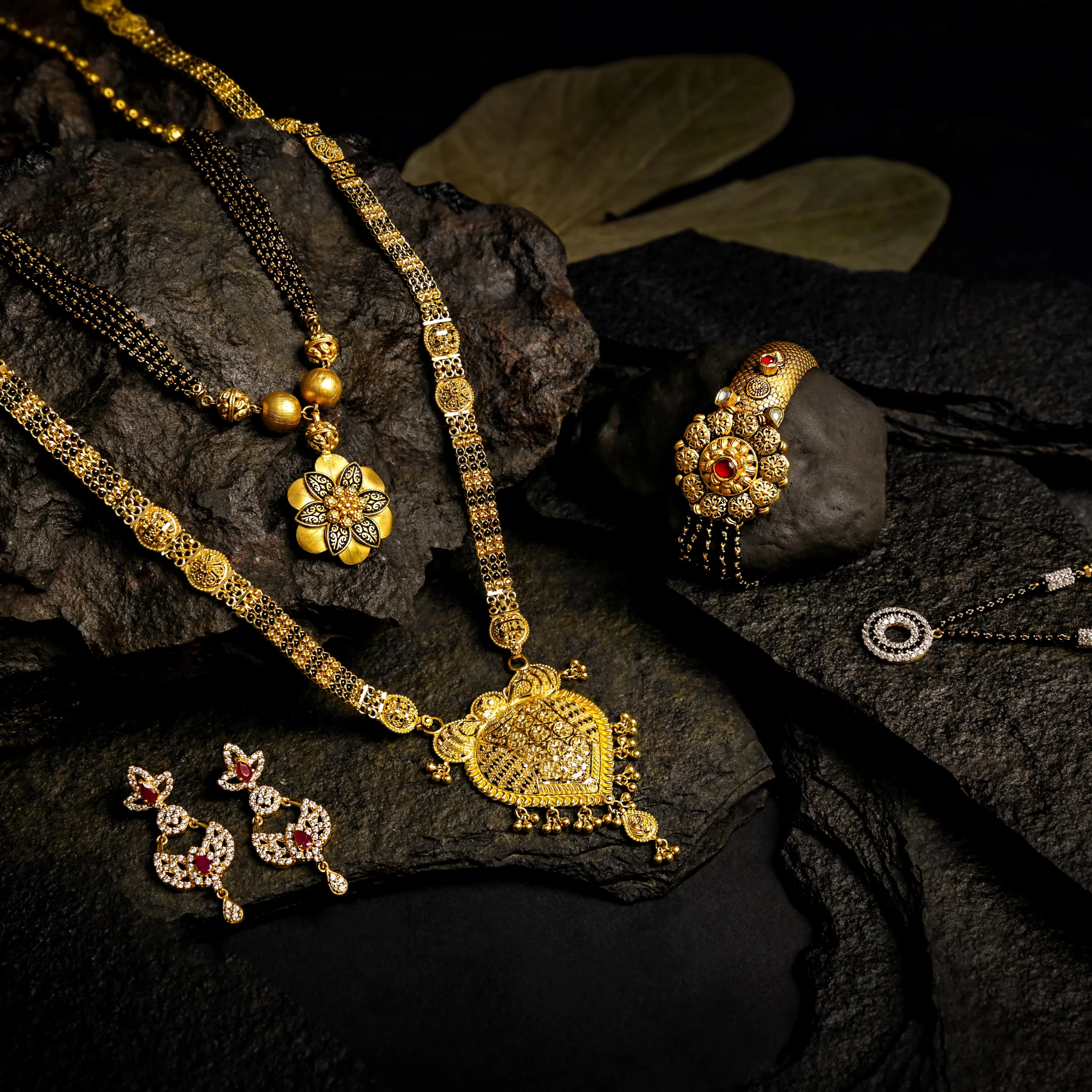 Photography Portfolio Traditional gold Mangalsutra jewelry collection with necklaces, rings and earrings on dark stone surfaces - Content Crest Media jewelry photography portfolio Ahmedabad Gujarat
